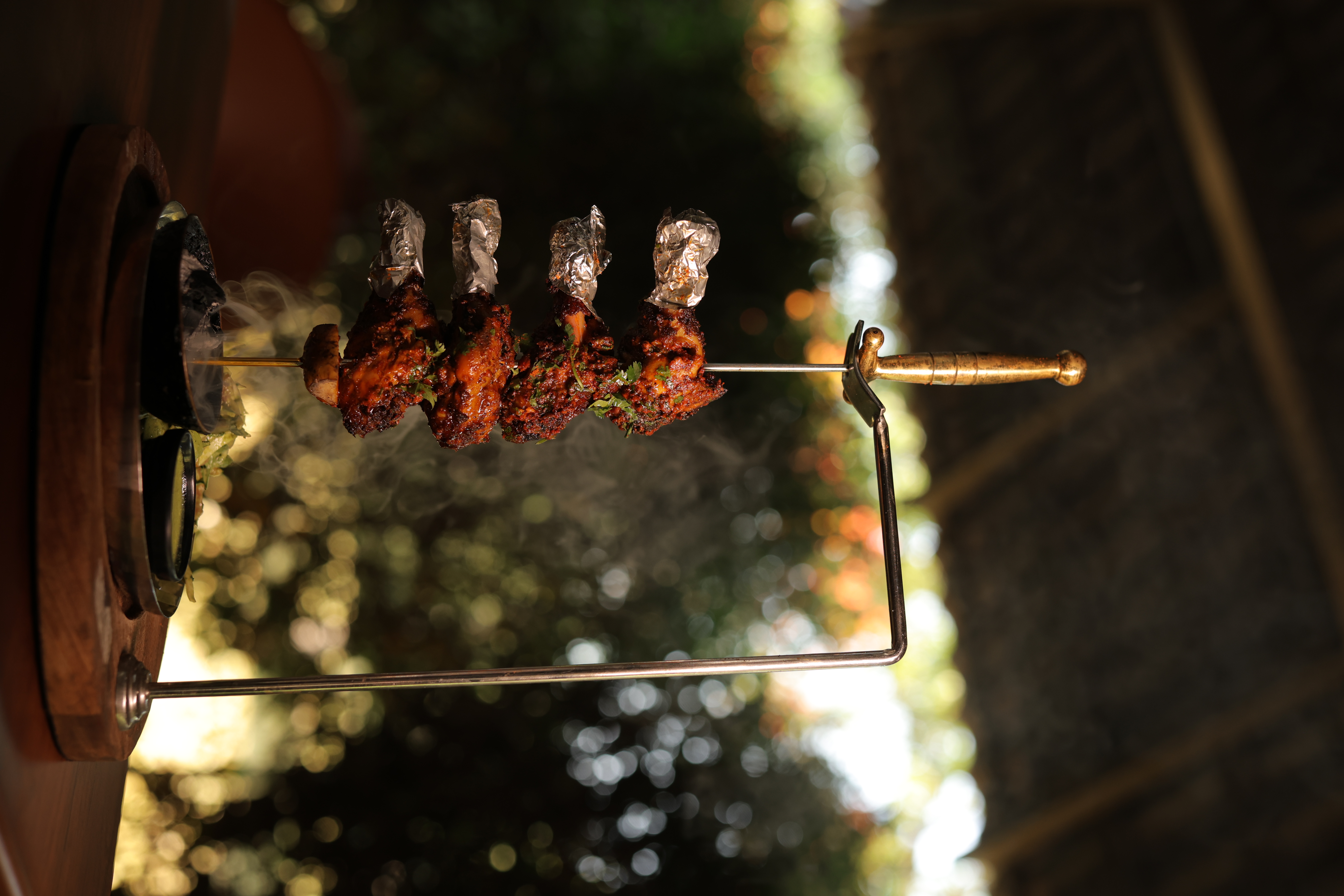 Tandoori chicken on a rotating skewer, freshly grilled at Jatra Countryside